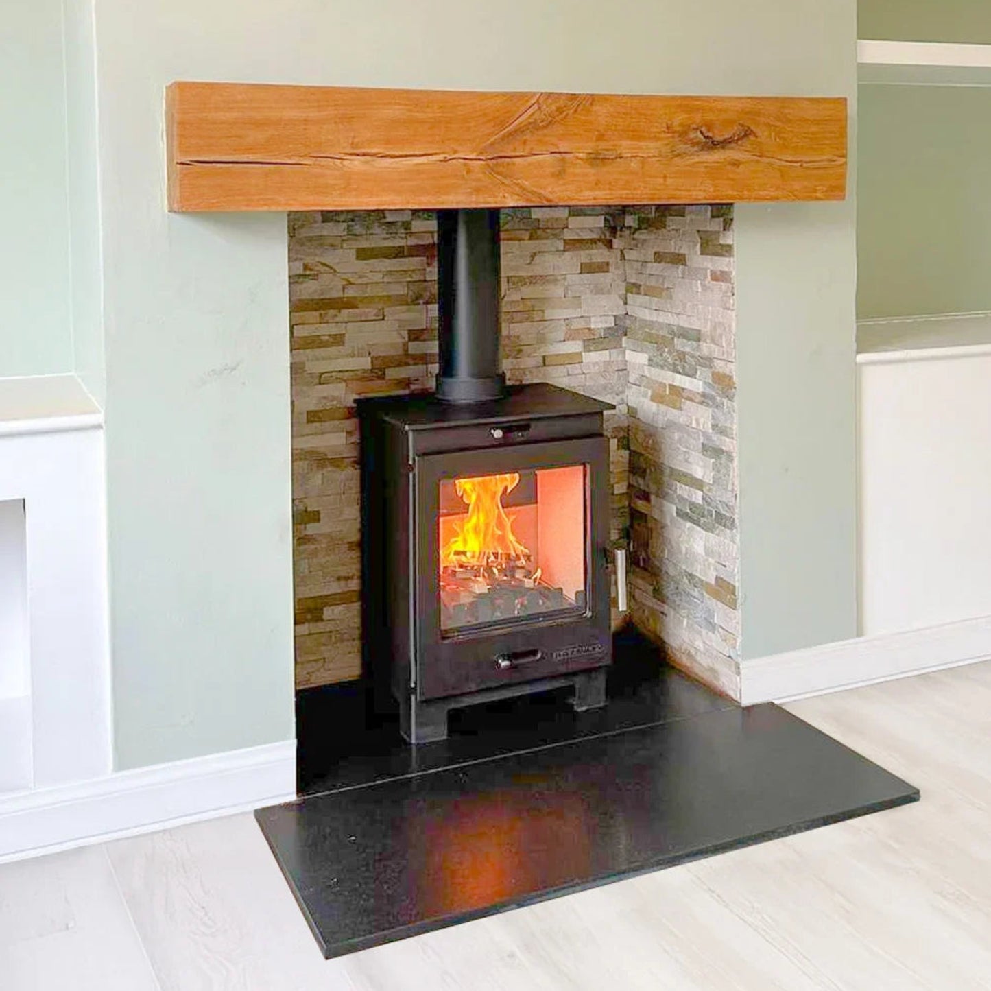 Wood-burning stove with a stone surround and wooden mantel in a room