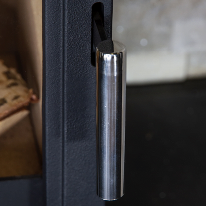 Close-up of a metallic handle on a black stove