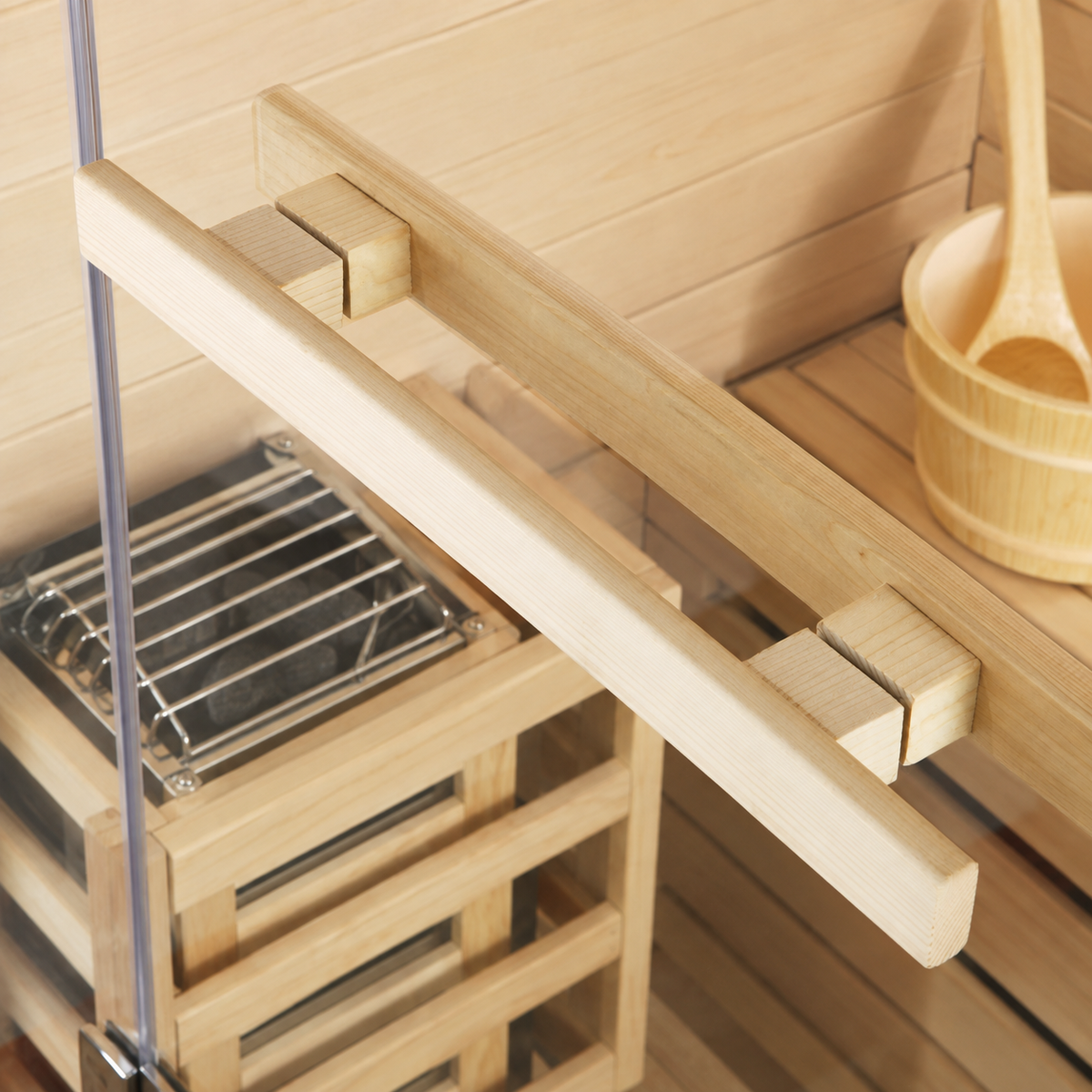 Close-up of a light natural wood sauna rack or shelf component with small square blocks, shown inside a wooden sauna alongside a metal grill and a bamboo bucket with a wooden spoon.