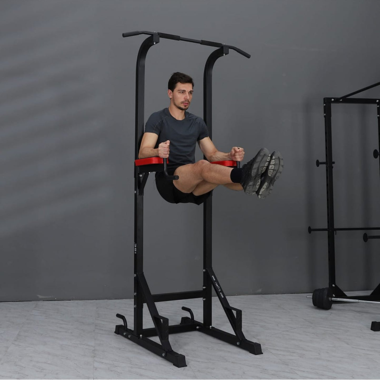 Person using a black and red pull-up bar station 