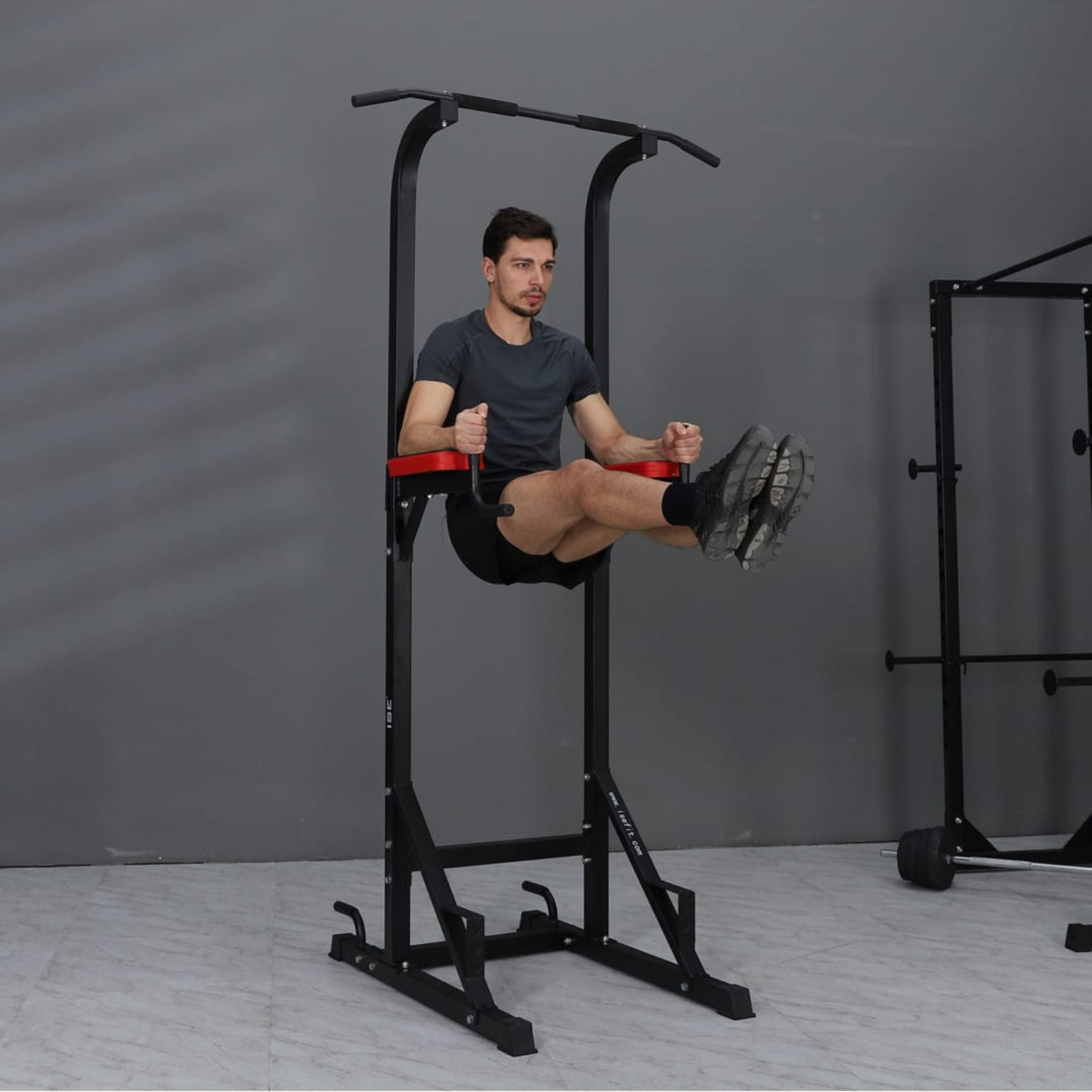Person using a black and red pull-up bar station 