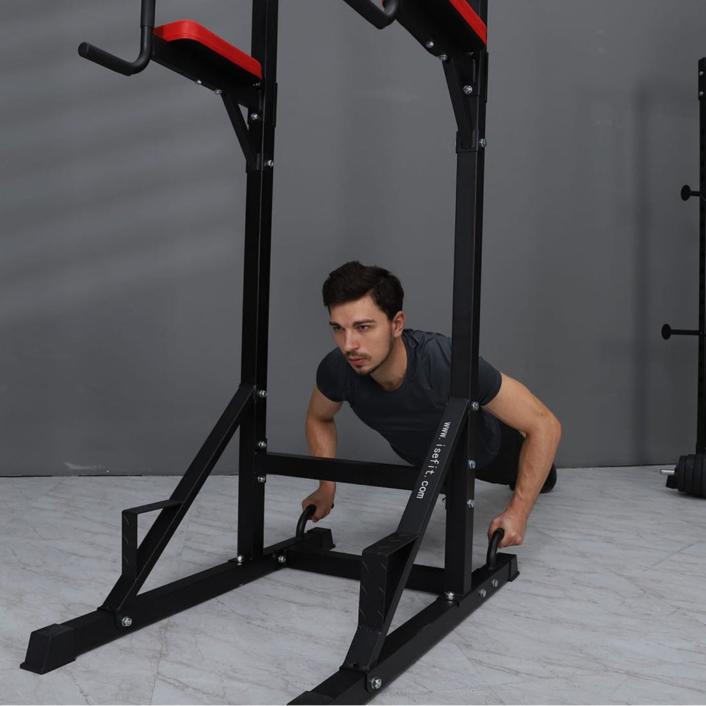Person using a black pull-up bar in a home gym setting
