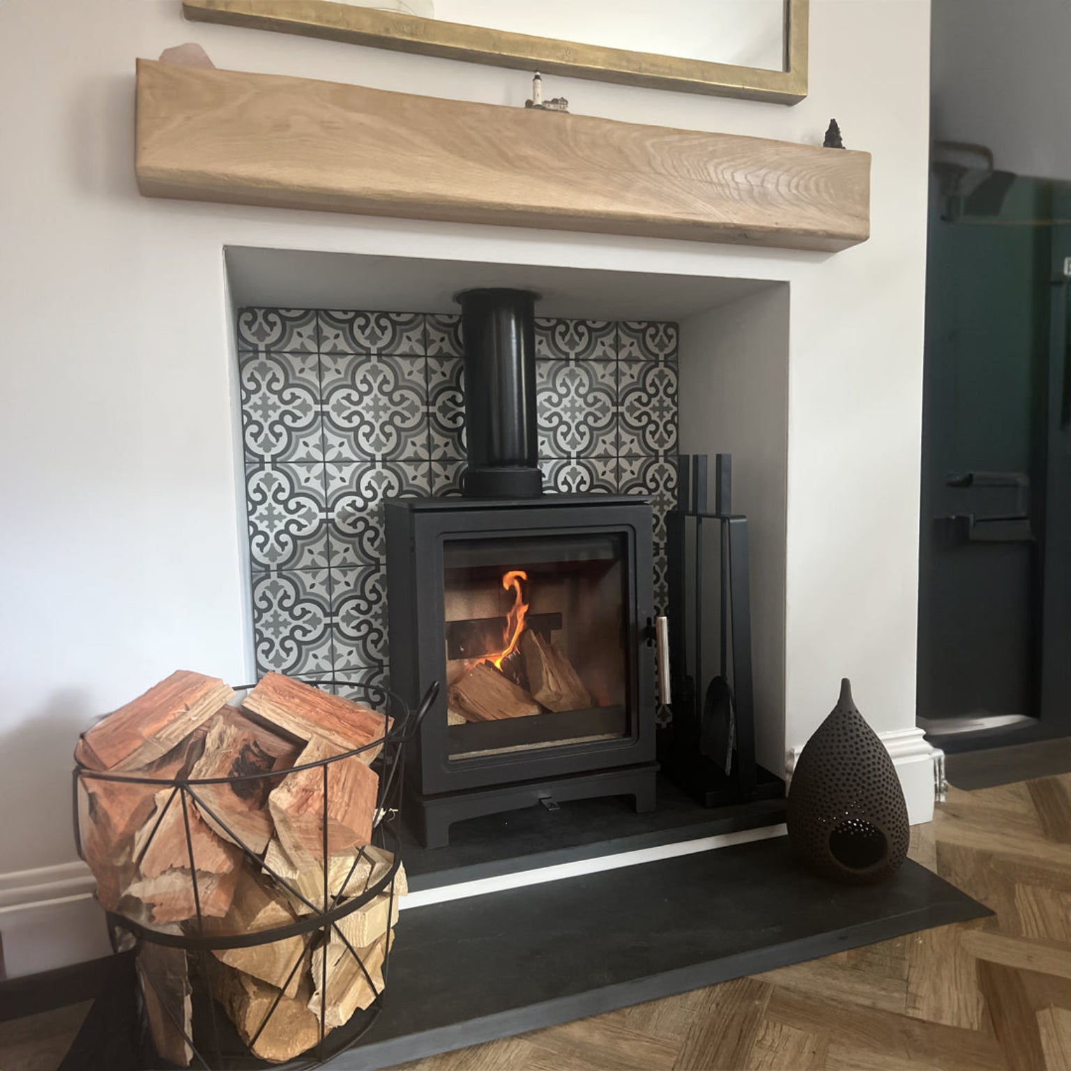 Wood-burning stove in a fireplace with decorative tiles 
